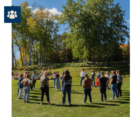 Retreat participants standing outside in a circle for a team building activity